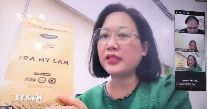 Chị Nguyễn Thiệp, đại diện công ty chè Mỹ Lâm, giới thiệu sản phẩm với các doanh nghiệp Algeria và Sénégal. (Ảnh: Mạnh Hùng/TTXVN)
