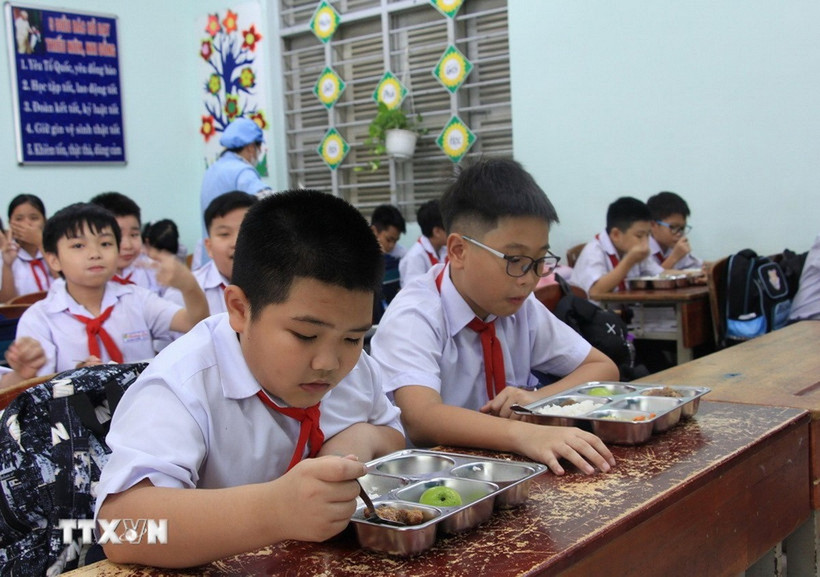 Học sinh vui vẻ với bữa ăn bán trú do Nhà trường tổ chức nấu. (Ảnh: Phan Sáu/TTXVN)