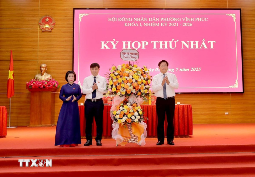 Chủ tịch UBND tỉnh, Phó Bí thư Tỉnh ủy Phú Thọ Trần Duy Đông (phải) tặng hoa chúc mừng lãnh đạo phường Vĩnh Phúc tại kỳ họp. (Ảnh: PV/TTXVN)