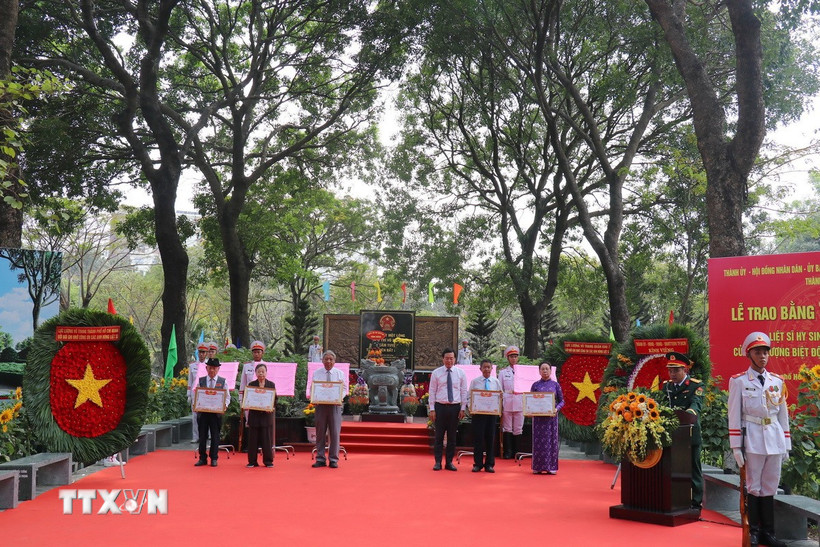Phó Bí thư Thường trực Thành ủy Thành phố Hồ Chí Minh Lê Quốc Phong trao Bằng “Tổ quốc ghi công” cho thân nhân 49 Anh hùng liệt sĩ Biệt động Quân khu Sài Gòn-Gia Định. (Ảnh: Thanh Vũ/TTXVN)