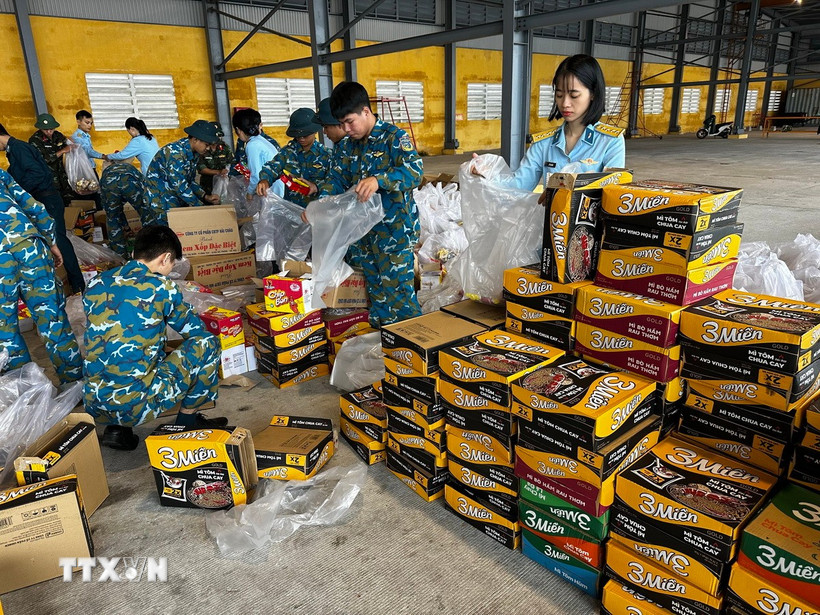 Hàng hóa, lương thực, thực phẩm, nhu yếu phẩm được vận chuyển, sắp xếp lên máy bay chuẩn bị hỗ trợ nhân dân vùng lũ. (Ảnh: Trần Lê Lâm/TTXVN)