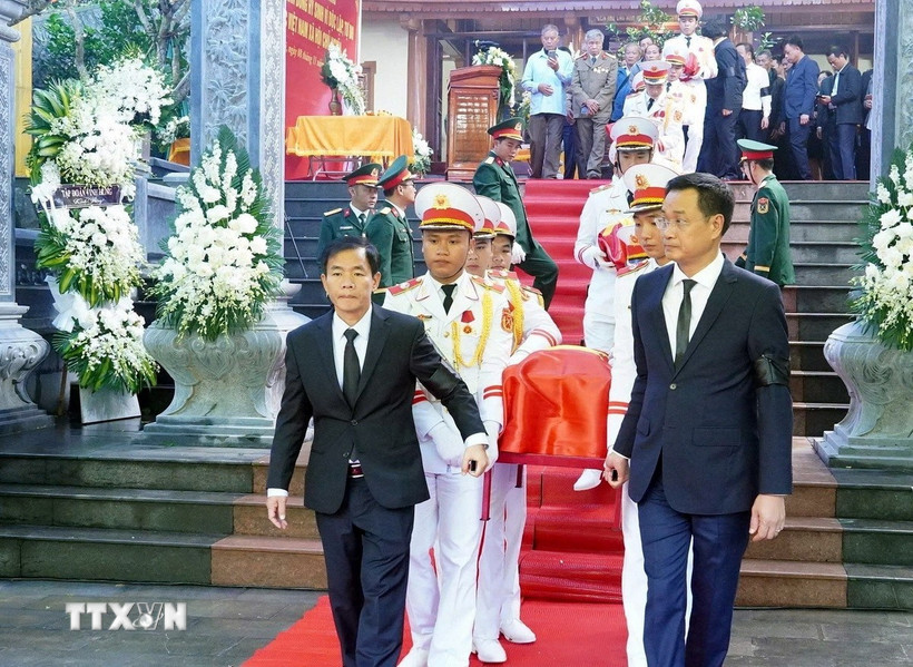 Đại biểu thực hiện nghi thức di quan để an táng các hài cốt các liệt sỹ. (Ảnh: TTXVN phát)