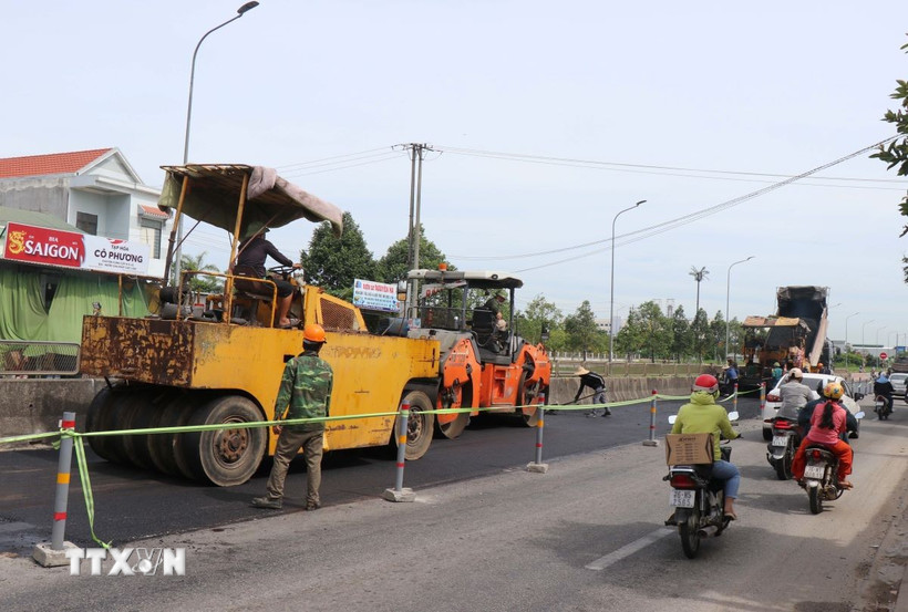 Thi công hoàn trả mặt bằng Quốc lộ 1 đoạn qua Khu công nghiệp VSIP. (Ảnh: Phạm Cường/TTXVN)
