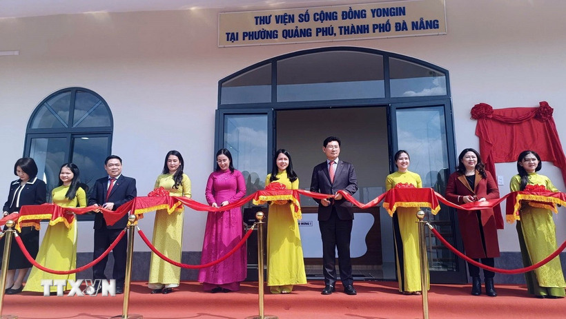 Đại biểu thực hiện nghi thức cắt băng khánh thành thư viện số. (Ảnh: Trần Tĩnh/TTXVN)