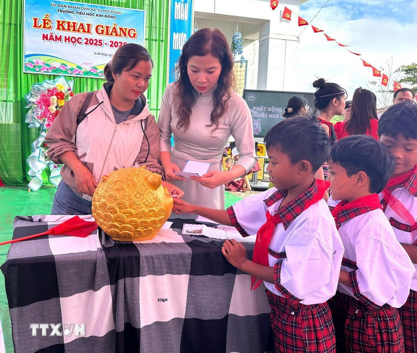 Giáo viên và học sinh trường Tiểu học Kim Đồng, xã Tu Mơ Rông (Quảng Ngãi) bỏ tiền heo đất gây quỹ duy trì bữa ăn trưa miễn phí và hỗ trợ cho những học sinh nghèo, mồ côi không thuộc diện bán trú. (Ảnh: TTXVN phát) 