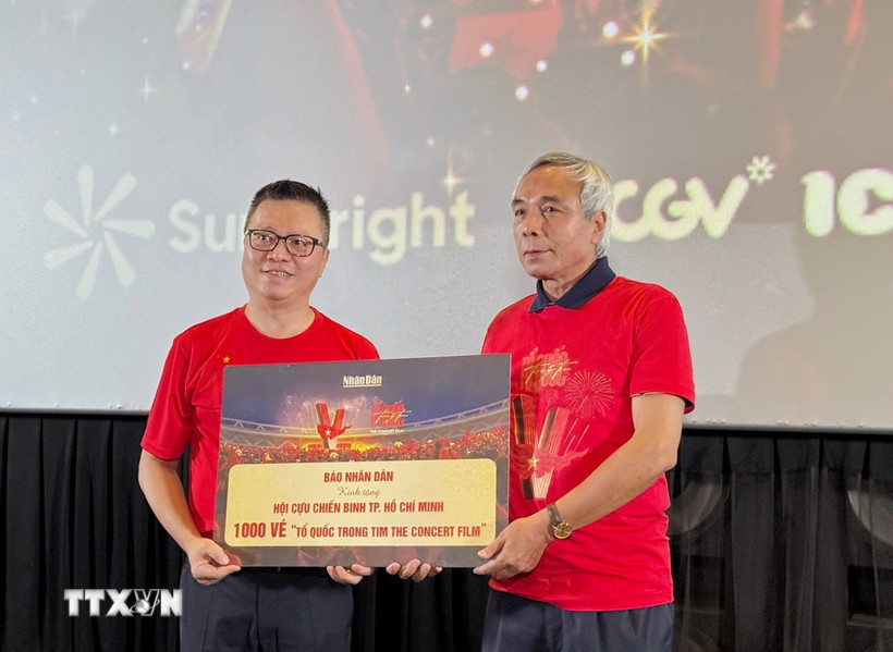 Tổng Biên tập Báo Nhân Dân Lê Quốc Minh trao tặng đến Hội Cựu Chiến binh Thành phố Hồ Chí Minh 1.000 tấm vé “Tổ Quốc Trong Tim: The Concert Film”. (Ảnh: Thu Hương/TTXVN) 