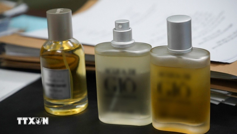 Các mẫu nước hoa giả các nhãn hiệu nổi tiếng do được cơ quan Công an thu giữ tại cơ sở của vợ chồng L.V.H và V.T.T. (Ảnh: TTXVN phát)