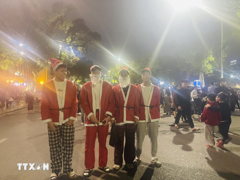 Phố đi bộ Hồ Hoàn Kiếm tấp nập du khách trong đêm Giáng sinh 2025. (Ảnh: Tuyết Mai/TTXVN)