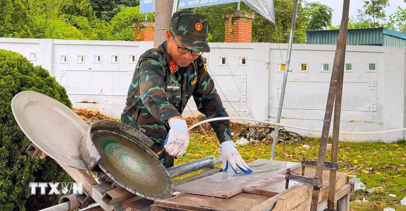 Trung tá Nguyễn Văn Ngọc với chiếc máy mòi đá. (Ảnh: TTXVN phát)