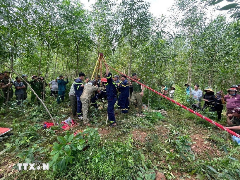 Cơ quan chức năng cứu hộ ông Phan Văn Hóa đang nằm dưới giếng sâu. (Ảnh: TTXVN phát)