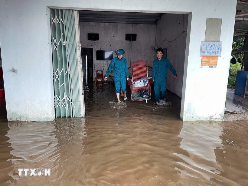 Lực lượng dân quân hỗ trợ người dân di chuyển đồ đạc khỏi vùng ngập lụt ven sông Krông Nô, tỉnh Lâm Đồng. (Ảnh: TTXVN phát)