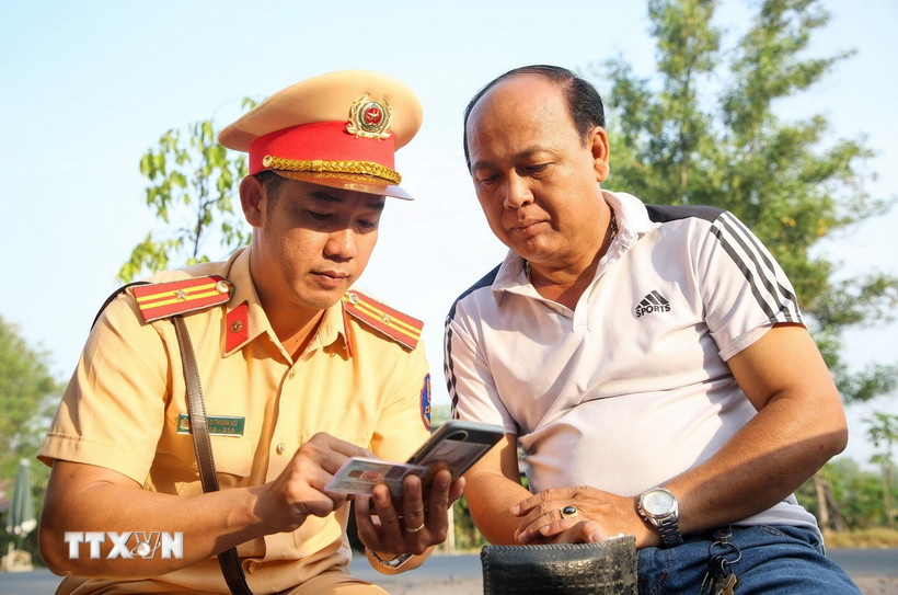 Cán bộ Cảnh sát giao thông Tây Ninh tuyên truyền pháp luật đến các chủ phương tiện. (Ảnh: Giang Phương/TTXVN)