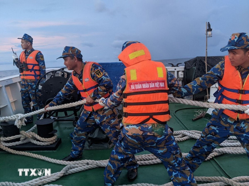 Các chiến sĩ giúp một tàu ngư dân bị nạn. (Ảnh: TTXVN phát)