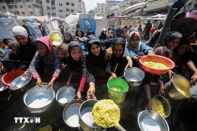 Người dân chờ được phát thực phẩm cứu trợ tại Gaza. (Ảnh: THX/TTXVN)