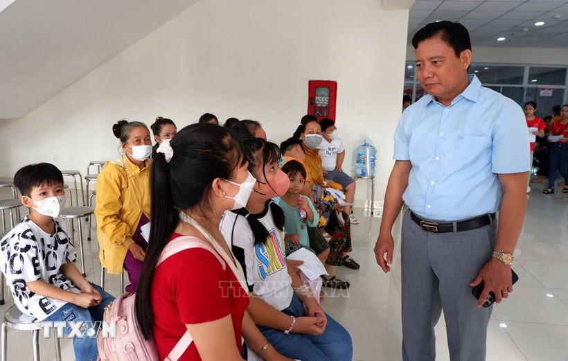 Phó Chủ tịch Ủy ban Nhân dân tỉnh Long An Phạm Tấn Hoà thăm hỏi các gia đình đưa trẻ em đến khám sàng lọc bệnh tim bẩm sinh. (Ảnh: Đức Hạnh/TTXVN)