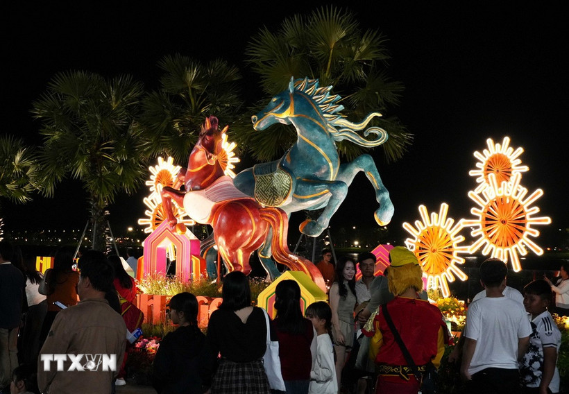 Du khách tham quan linh vật ngựa ở bờ Nam sông Hương, thành phố Huế dịp Tết Bính Ngọ 2026. (Ảnh: Nguyên Lý/TTXVN)