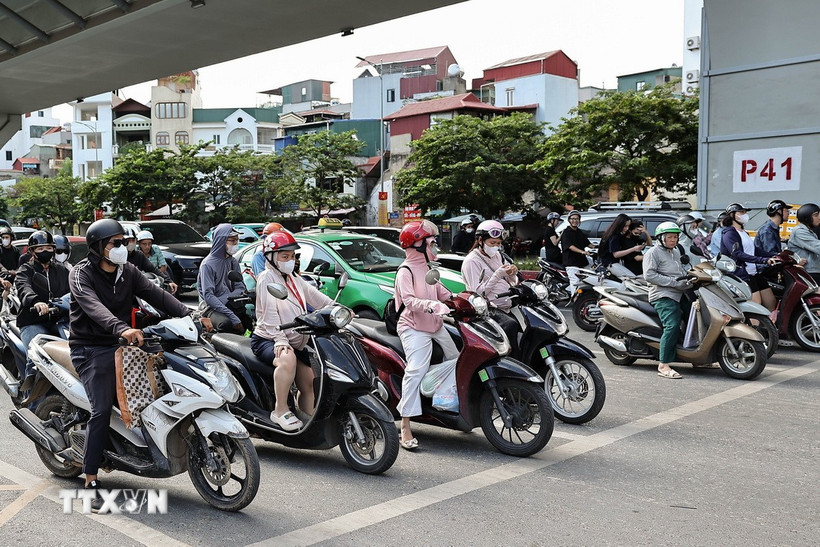 Áo chống nắng, khẩu trang là những vật không thể thiếu của người dân khi tham gia giao thông. (Ảnh: Vũ Quang/TTXVN)