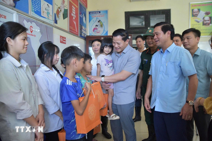 Chủ tịch Ủy ban Nhân dân tỉnh Bắc Ninh Vương Quốc Tuấn (thứ 2, phải sang) động viên, tặng quà trẻ em xã Tam Giang. (Ảnh: Thái Hùng/TTXVN)
