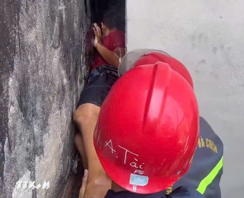 Cảnh sát Phòng cháy, chữa cháy và Cứu nạn, cứu hộ Công an Thành phố Hồ Chí Minh giải cứu kịp thời bé trai mắc kẹt giữa hai bức tường ở phường Bình Cơ. (Ảnh: TTXVN phát)