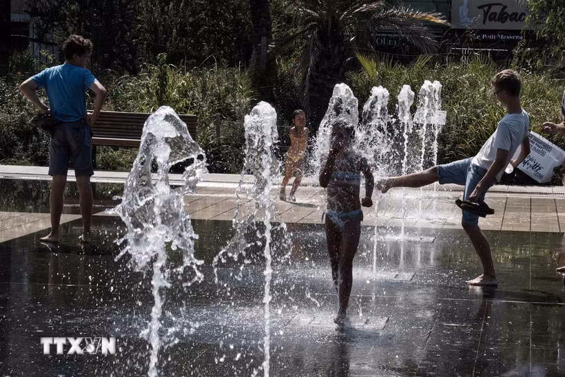 Người dân tránh nóng bên đài phun nước ở Nice, Pháp. (Ảnh: THX/TTXVN)