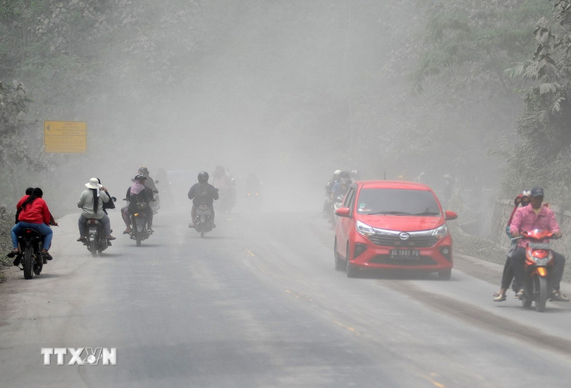 Tro bụi phun ra từ miệng núi lửa Semeru tràn xuống ngôi làng ở Đông Java, Indonesia ngày 23/11/2025.( Ảnh: THX/TTXVN)