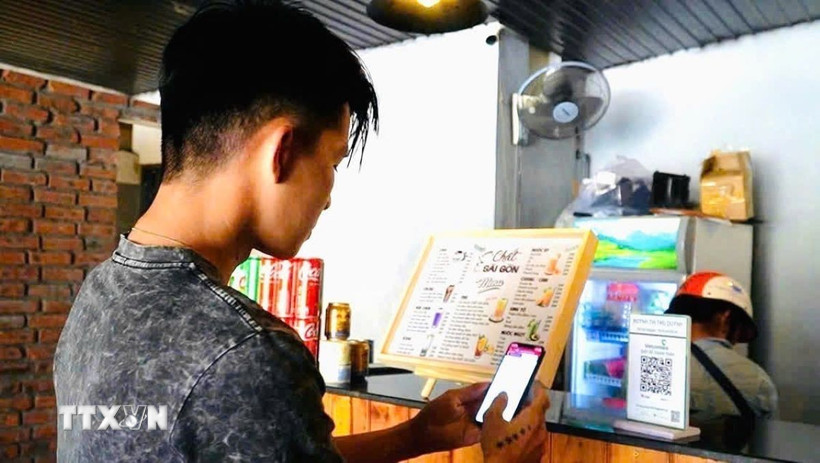 Khách hàng sử dụng phương thức giao dịch thanh toán trực tuyến. (Ảnh: TTXVN phát)
