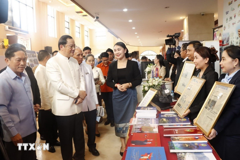 Thủ tướng Lào Sonexay Siphandone và các đại biểu tham quan gian hàng của TTX Lào (KPL) - nơi trưng bày ấn phẩm Báo ảnh của TTXVN. (Ảnh: Xuân Tú/TTXVN)