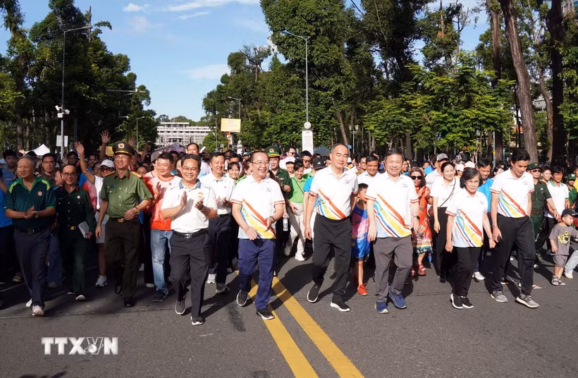 Lãnh đạo Thành phố Hồ Chí Minh cùng đại biểu, cán bộ, chiến sỹ, đoàn viên, thanh niên và người dân tham gia Chương trình đi bộ đồng hành kỷ niệm 50 năm Ngày Thành phố Sài Gòn-Gia Định chính thức vinh dự mang tên Chủ tịch Hồ Chí Minh. (Ảnh: Trung Tuyến/TTXVN)