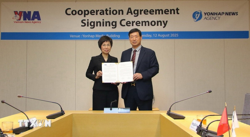 Tổng Giám đốc TTXVN Vũ Việt Trang và Chủ tịch Yonhap Hwang Dae Il công bố Văn kiện ký kết. (Ảnh: Đức Thắng/TTXVN)