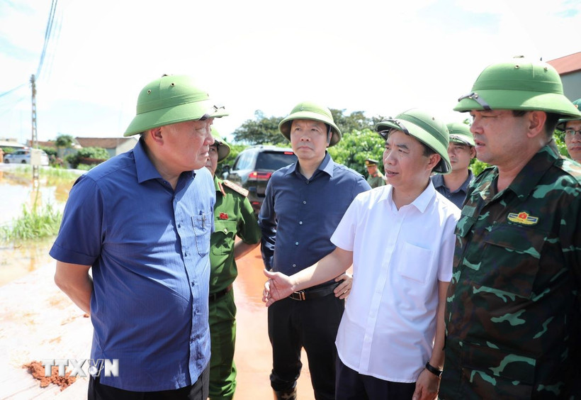 Phó Thủ tướng Thường trực Nguyễn Hòa Bình (đầu tiên, trái sang) nghe báo cáo tình hình mưa lũ. (Ảnh: Danh Lam/TTXVN)