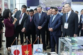 Tổng Bí thư Tô Lâm, Thủ tướng Phạm Minh Chính và các đại biểu thăm quan triển lãm. (Ảnh: Thống Nhất/TTXVN)