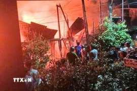 Lực lượng chức năng nỗ lực khống chế đám cháy ở ấp Hòa Phát, xã Hòa Lạc, An Giang. (Ảnh: TTXVN phát)