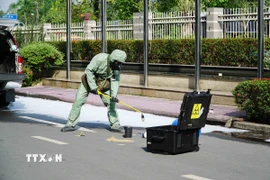Lực lượng chức năng tiến hành thu hồi nguồn phóng xạ. (Ảnh: Thu Hoài/TTXVN)