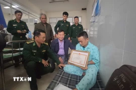 Chính ủy Bộ đội Biên phòng tỉnh Gia Lai Đoàn Văn Báu trao tặng Bằng khen cho Thiếu tá Nguyễn Khắc Thinh. (Ảnh: Sỹ Thắng/TTXVN)