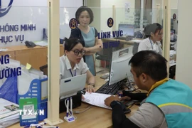 Cán bộ, công chức tận tình giải đáp thắc mắc, hỗ trợ giải quyết hồ sơ cho nhân dân tại Điểm phục vụ Hành chính công Hai Bà Trưng, Hà Nội. (Ảnh: Vũ Quang/TTXVN)