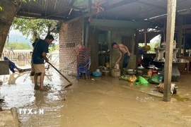 Sau khi nước rút, người dân Đắk Lắk tranh thủ dọn bùn, rác. (Ảnh: Nguyên Dung/TTXVN)