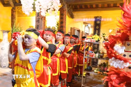 Các túi lương được vận chuyên từ cung cấm Đền Trần thương ra các cửa phía ngoài để phát cho người dân và du khách thập phương. (Ảnh: Đại Nghĩa/TTXVN)