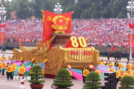 Xe mô hình Quốc huy nước Cộng hòa xã hội chủ nghĩa Việt Nam đi đầu khối diễu binh, diễu hành. (Ảnh: TTXVN)