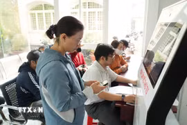 Người dân thao tác quét VNeID để làm thủ tục hành chính tại Trung tâm Phục vụ Hành chính công xã Củ Chi. (Ảnh: Hữu Duyên/TTXVN)
