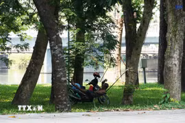 Người dân đến công viên ở bờ Bắc sông Hương, phường Phú Xuân, thành phố Huế, để hóng mát, tránh nắng nóng gay gắt. (Ảnh: Nguyên Lý/TTXVN)