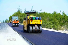 Máy móc thi công thảm nhựa tại Dự án đường trục ngang ven biển Thạch Hà. (Ảnh: Hữu Quyết/TTXVN)