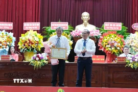 Phó Chủ tịch Ủy ban Nhân dân thành phố Cần Thơ Trần Chí Hùng trao Bằng khen của Chủ tịch Ủy ban Nhân dân thành phố cho Anh hùng lao động, kỹ sư Hồ Quang Cua. (Ảnh: Thanh Liêm/TTXVN)