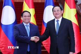 Thủ tướng Phạm Minh Chính gặp Thủ tướng Lào Sonexay Siphandone. (Ảnh: Dương Giang/TTXVN)