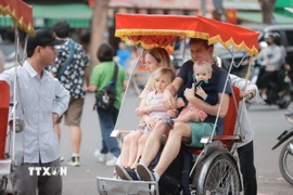 Du khách quốc tế tham quan Hà Nội bằng xích lô. (Ảnh: Minh Quyết/TTXVN)