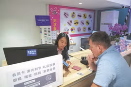 Một nhân viên của cửa hàng bách hóa ở Bắc Kinh giúp một du khách nước ngoài hoàn thuế. (Nguồn: Xinhua)