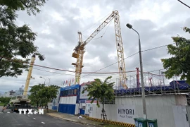 Cần cẩu tháp cao khoảng 30 mét bị gãy trục ngang, đổ xuống công trình. (Ảnh: Quốc Dũng/TTXVN)