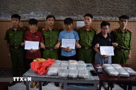 Ba đối tượng bị bắt giữ cùng tang vật vụ án. (Ảnh: TTXVN phát)