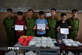 Ba đối tượng bị bắt giữ cùng tang vật vụ án. (Ảnh: TTXVN phát)