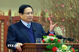 Thủ tướng Phạm Minh Chính chúc mừng năm mới Ất Tỵ ngành ngân hàng. (Ảnh: Dương Giang/TTXVN)