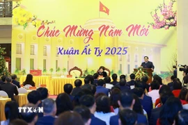 Thủ tướng Phạm Minh Chính chúc mừng năm mới Ất Tỵ ngành ngân hàng. (Ảnh: Dương Giang/TTXVN)